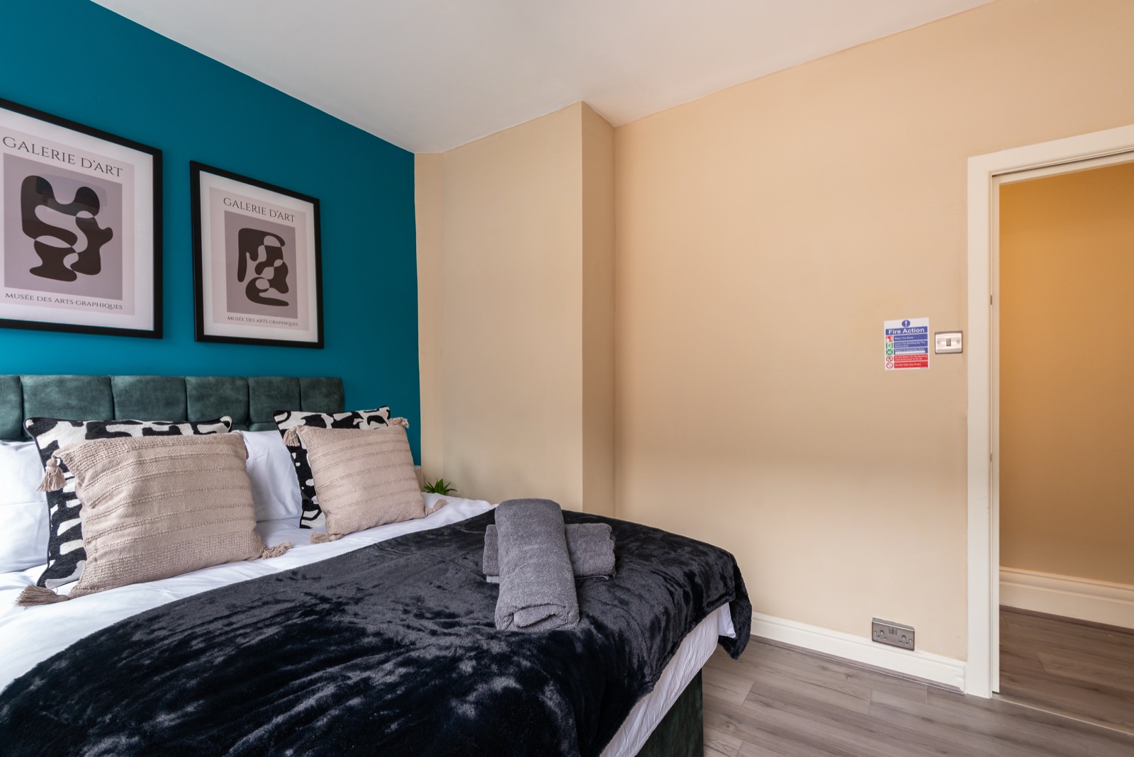 Bedroom at Ash Grove House — teal accent wall, framed art