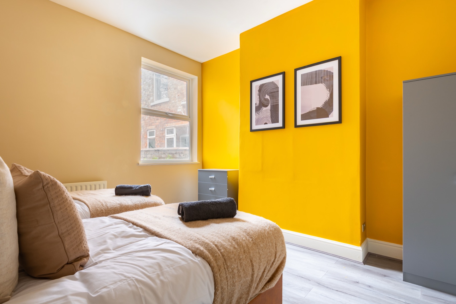 Twin bedroom at Ash Grove House — mustard accent wall