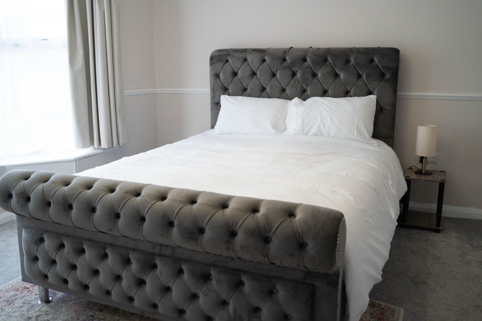 Master bedroom at Cecil House — grey velvet sleigh bed